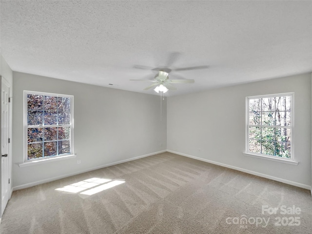 carpeted spare room with a ceiling fan, a textured ceiling, and baseboards