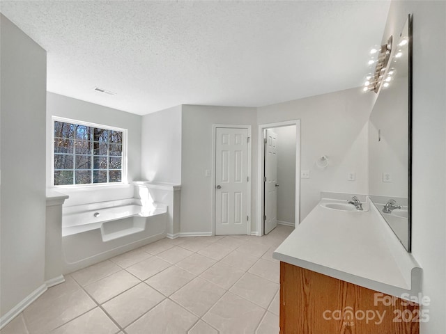 full bathroom with a textured ceiling, a sink, a bath, and tile patterned floors