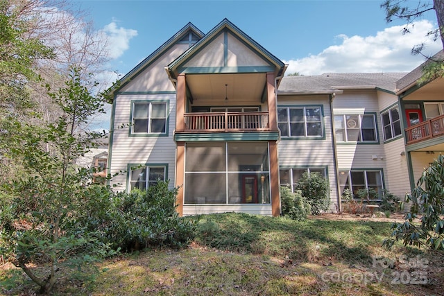 rear view of house with a sunroom and a balcony