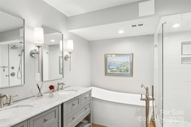 full bathroom featuring a shower stall, a sink, visible vents, and double vanity