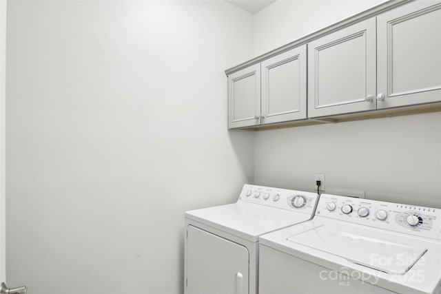 washroom with washing machine and dryer and cabinet space