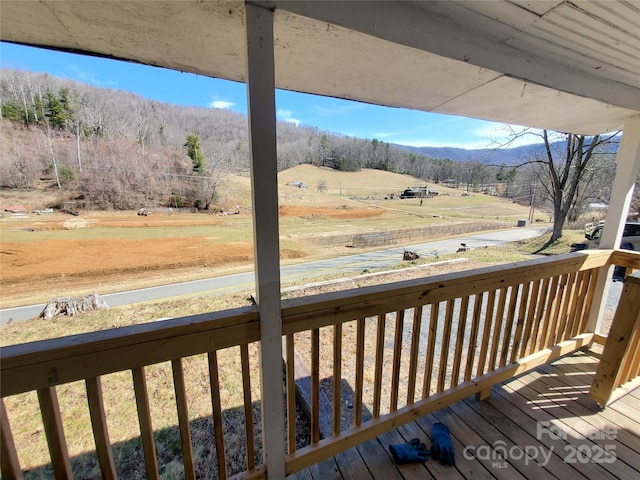 wooden deck featuring a rural view and a mountain view