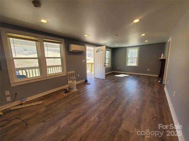 interior space featuring dark wood finished floors, recessed lighting, an AC wall unit, and baseboards