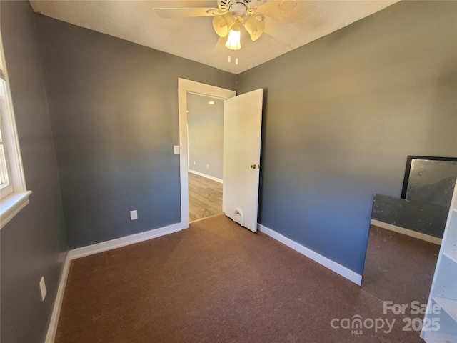 unfurnished bedroom with baseboards, carpet floors, and a ceiling fan