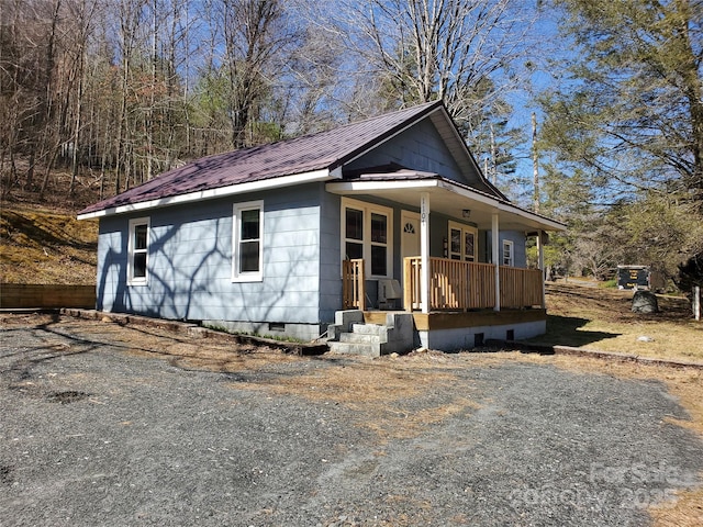 view of front of home with a porch, metal roof, and crawl space