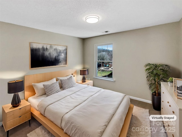 bedroom with visible vents, baseboards, and a textured ceiling