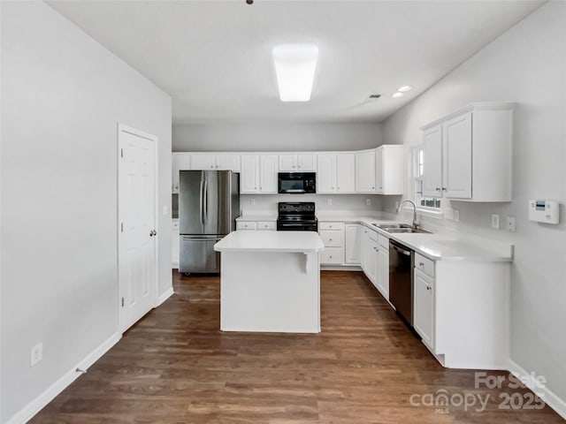 kitchen featuring light countertops, white cabinetry, a sink, and black appliances