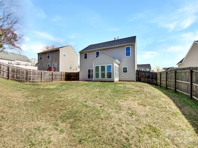 back of property with a lawn and a fenced backyard