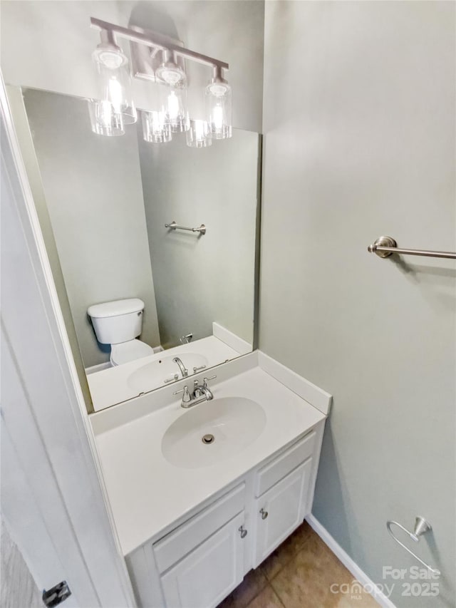 bathroom featuring toilet, tile patterned floors, baseboards, and vanity