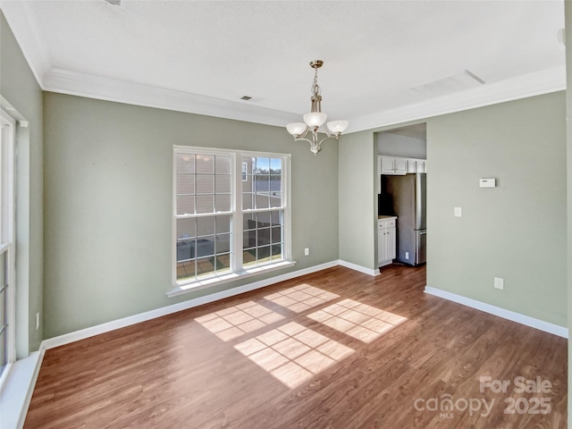 unfurnished dining area with a notable chandelier, wood finished floors, visible vents, baseboards, and ornamental molding