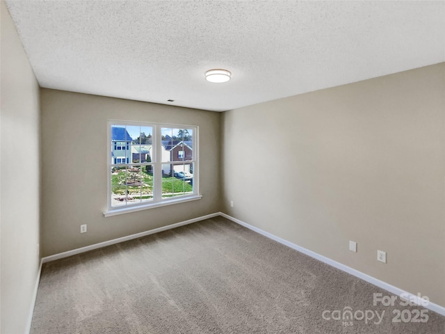 unfurnished room with carpet floors, a textured ceiling, and baseboards