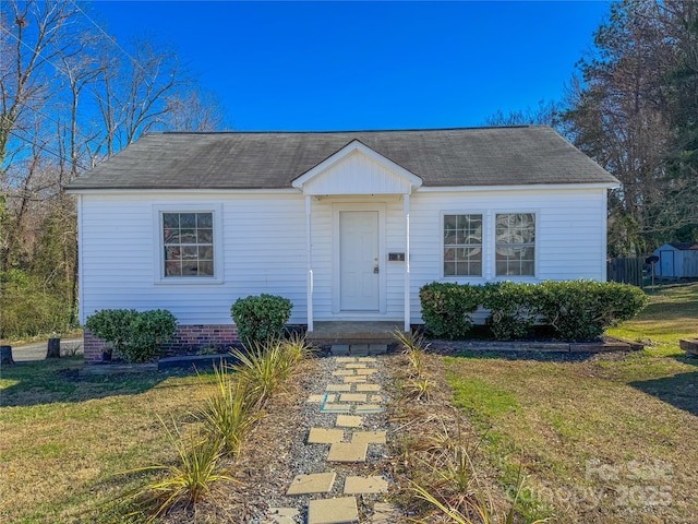 view of front of property featuring an outdoor structure, a front lawn, and a storage unit