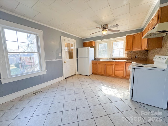 kitchen with crown molding, visible vents, light tile patterned flooring, a sink, and white appliances