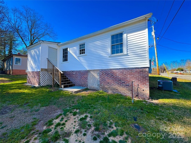 back of house featuring entry steps and a yard