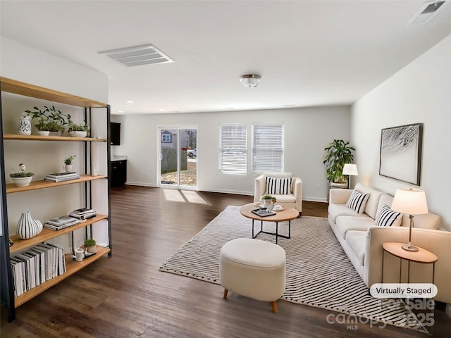 living area featuring baseboards, visible vents, and dark wood-style flooring