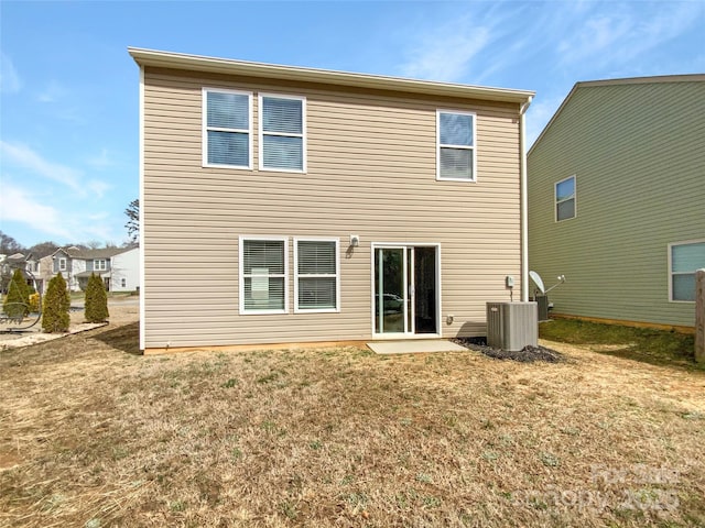 rear view of property featuring central AC and a yard