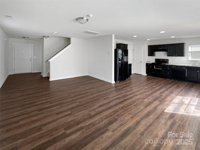 unfurnished living room with dark wood finished floors, recessed lighting, visible vents, stairway, and baseboards