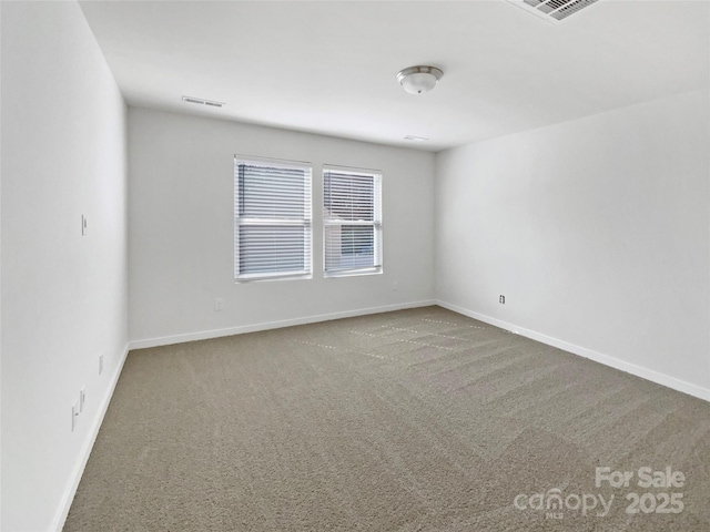 carpeted empty room with visible vents and baseboards