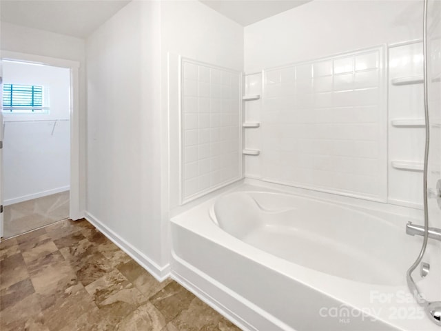 bathroom featuring bathtub / shower combination and baseboards