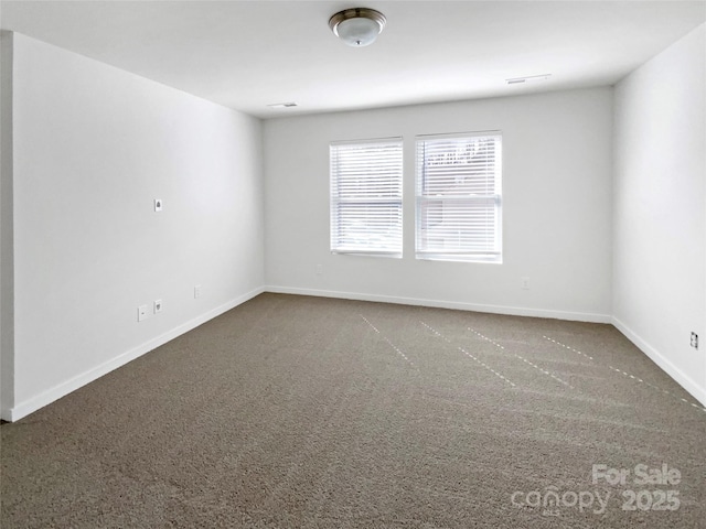 carpeted empty room featuring baseboards