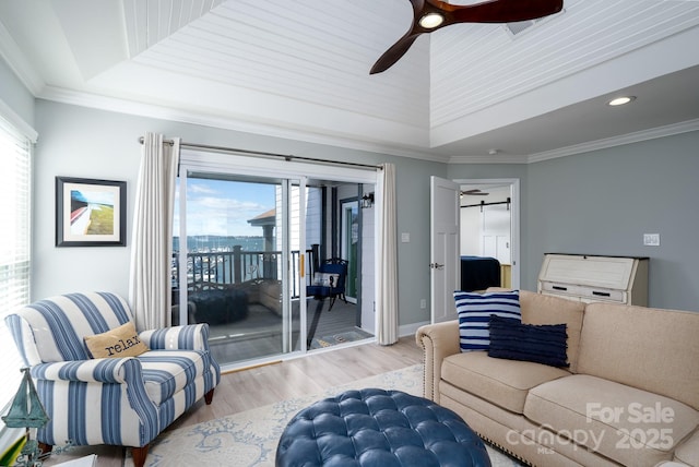 living area featuring recessed lighting, wood finished floors, a ceiling fan, ornamental molding, and a raised ceiling