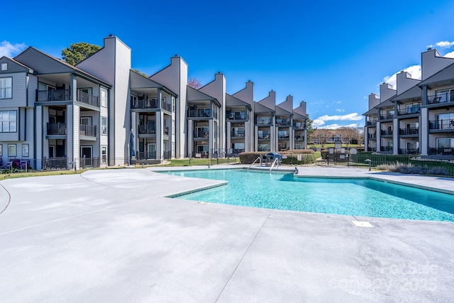 community pool with fence and a patio