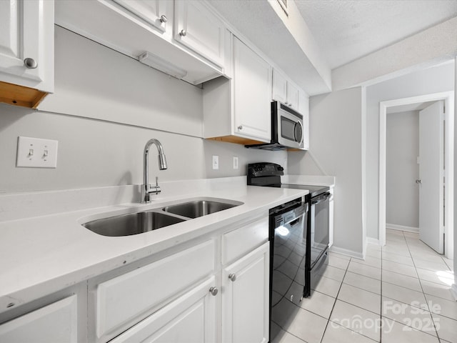 kitchen with white cabinets, light countertops, a sink, and black appliances