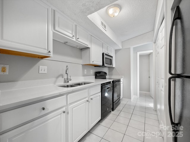 kitchen with visible vents, light countertops, black appliances, white cabinetry, and a sink