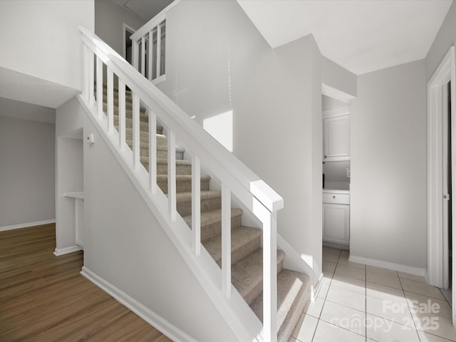 stairway featuring tile patterned flooring and baseboards