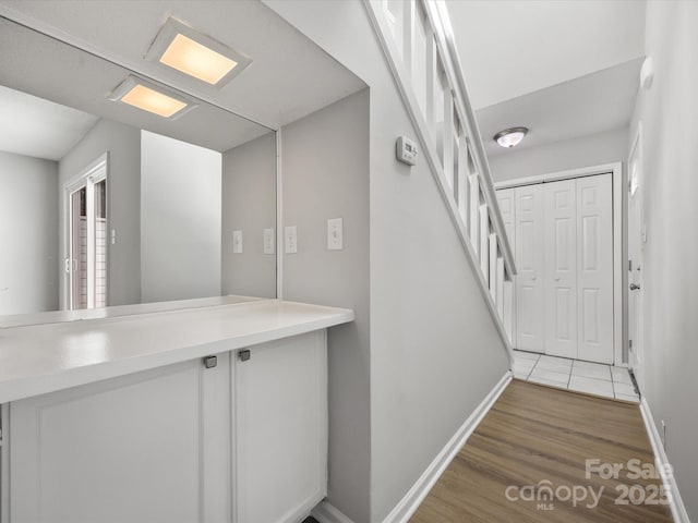 interior space featuring baseboards, stairway, and light wood-style floors