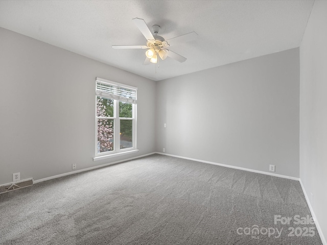 unfurnished room with a ceiling fan, baseboards, visible vents, and carpet flooring