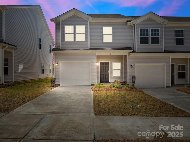 townhome / multi-family property featuring driveway and an attached garage