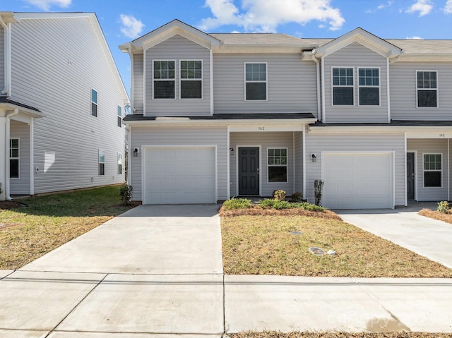 view of front facade featuring a garage, concrete driveway, and a front lawn