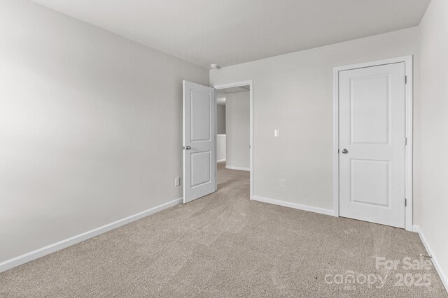 unfurnished bedroom with carpet floors and baseboards