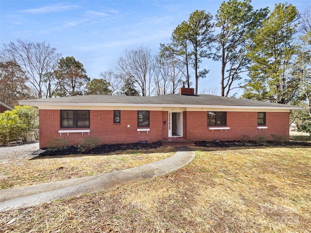 single story home featuring a chimney, a front lawn, and brick siding