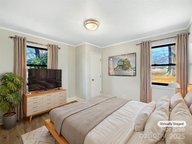 bedroom with ornamental molding, multiple windows, and light wood-type flooring