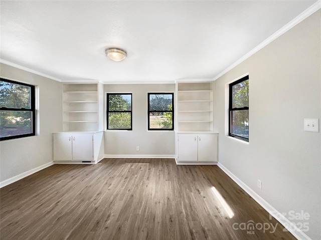 unfurnished room with baseboards, wood finished floors, and ornamental molding