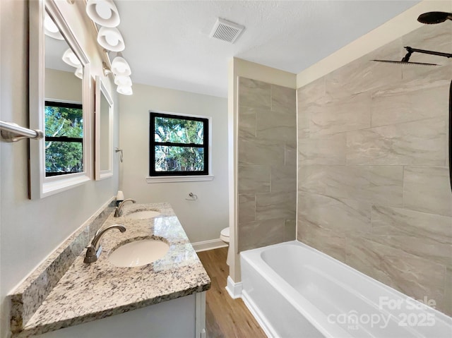 bathroom featuring a wealth of natural light, visible vents, and a sink