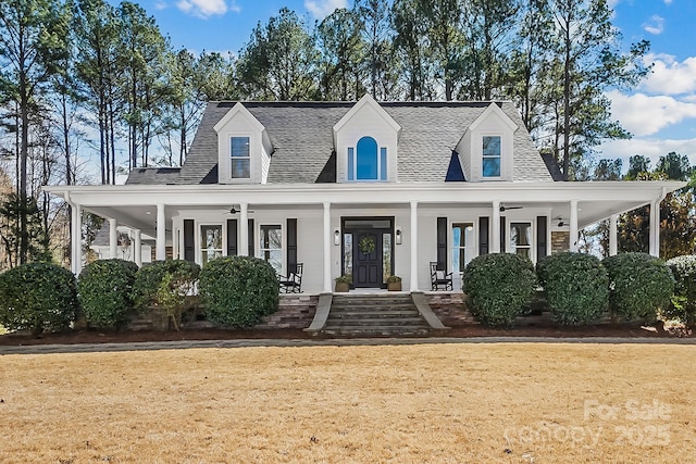 view of front facade featuring covered porch, a front yard, a ceiling fan, and a shingled roof