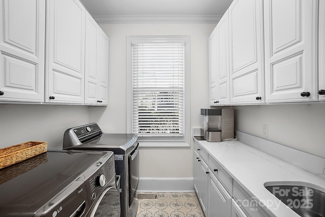 laundry room with baseboards, cabinet space, ornamental molding, and washing machine and clothes dryer