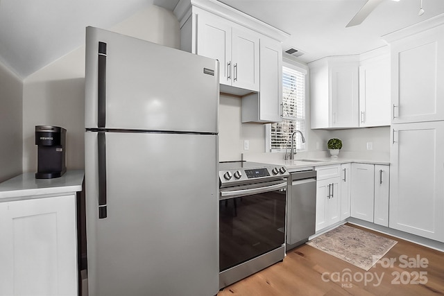 kitchen with visible vents, light wood-style floors, appliances with stainless steel finishes, white cabinets, and light countertops