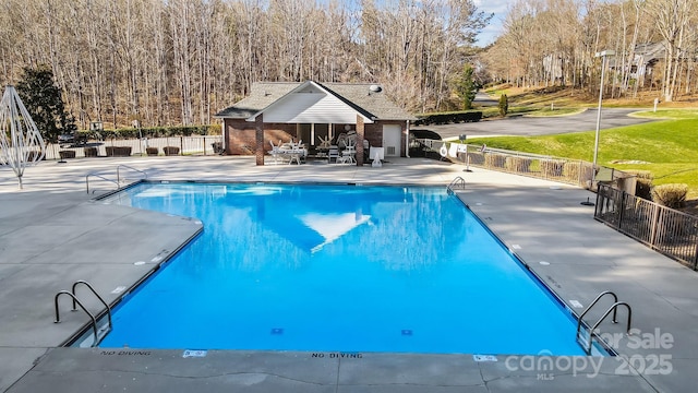 pool featuring a storage structure, an outbuilding, fence, and a patio area