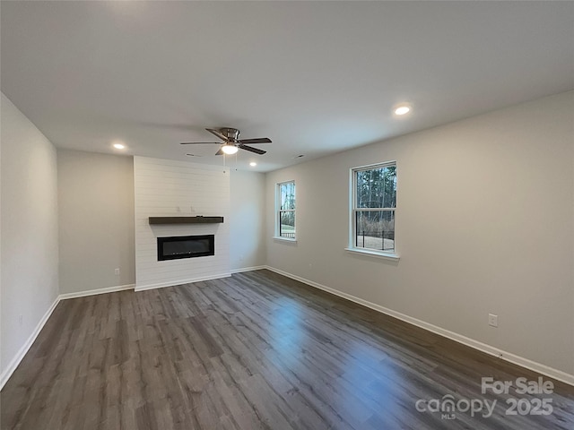 unfurnished living room featuring a fireplace, recessed lighting, dark wood-type flooring, a ceiling fan, and baseboards