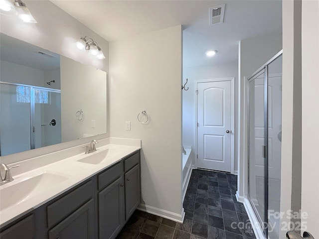 bathroom featuring double vanity, visible vents, a stall shower, a sink, and baseboards