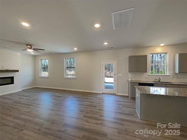 kitchen featuring gray cabinets, visible vents, a fireplace, and a healthy amount of sunlight