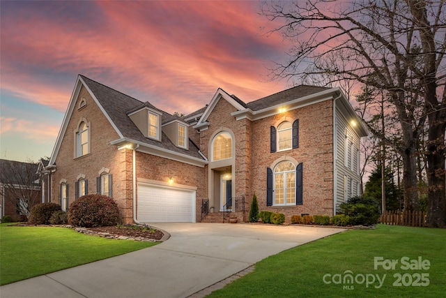 view of front facade with a front yard, a garage, brick siding, and driveway