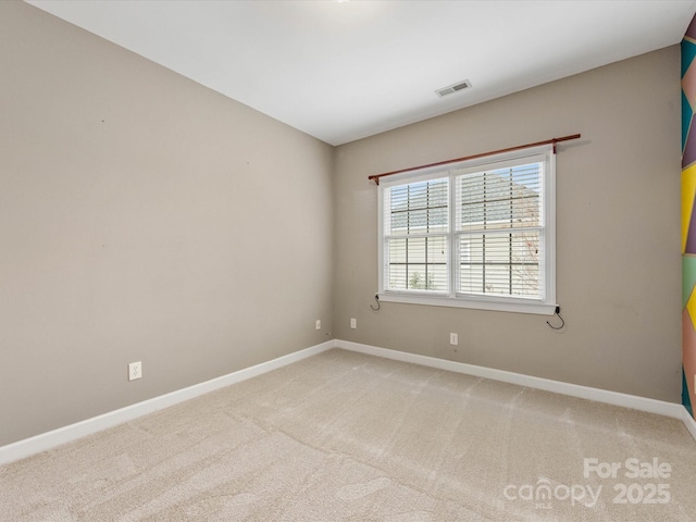 empty room featuring visible vents, light carpet, and baseboards