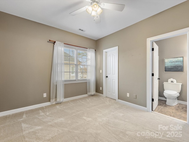 unfurnished bedroom with visible vents, baseboards, carpet flooring, ensuite bathroom, and a ceiling fan