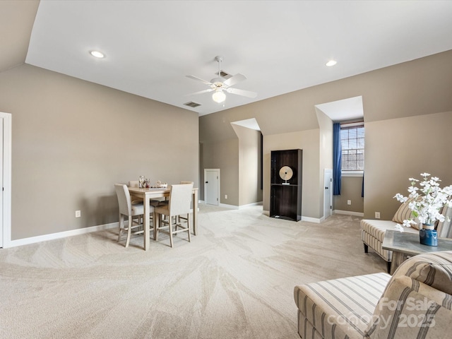 living room featuring visible vents, baseboards, light colored carpet, vaulted ceiling, and a ceiling fan