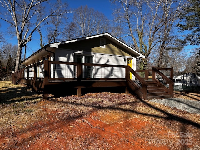 view of home's exterior with brick siding and a wooden deck